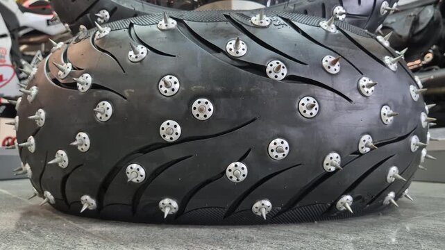 A huge tire with metal spikes for racing on ice or black ice