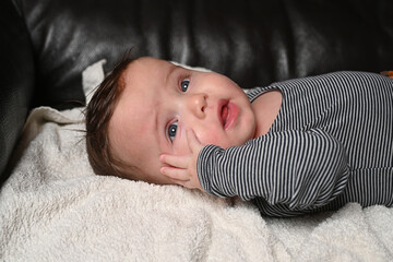 child lying on a sofa while his mother prepares him