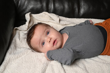 child lying on a sofa while his mother prepares him