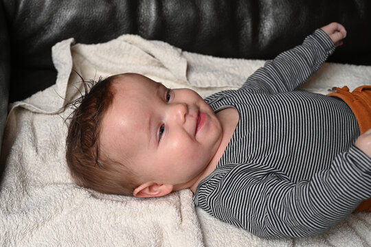 child lying on a sofa while his mother prepares him