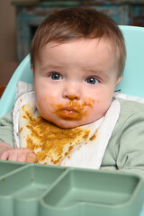 young child facing forward with applesauce on his face