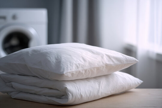 Clean white pillow and duvet stacked on wooden table, soft natural light from window, cozy home laundry room interior, fresh bedding, comfortable and inviting atmosphere, relaxation and cleanliness