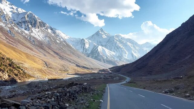 Traveling on curved road leading towards a  Snowy peak known as Makra Peak in Naran Kaghan, Pakistan