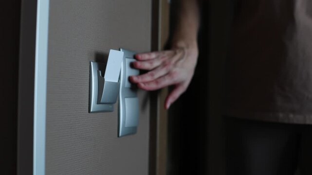 A person inserts a key card into a slot to activate the lights in a hotel room.