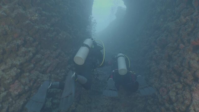 log footage of scuba divers exploring caves underwater