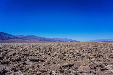 A vast, empty desert with a clear blue sky above