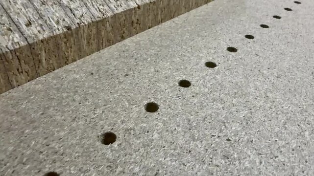 holes in furniture parts for assembly. pieces of chipboard with drilled holes for fastening and assembly. kitchen frame parts in furniture production.