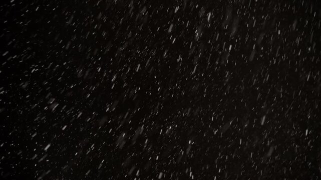 Authentic snow falling footage with variable wind gusts against black sky. Real snowflakes in high 4K resolution, isolated background ideal for overlays, VFX and winter effects.