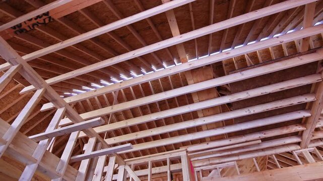Wooden beams trusses create strong roof in building under construction