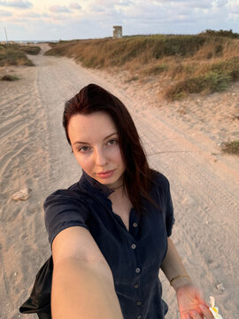 Women doing selfie on the beach in sunset