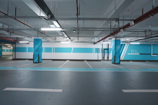 Empty parking space in underground garage level B3 with blue and white signage and clean industrial design
