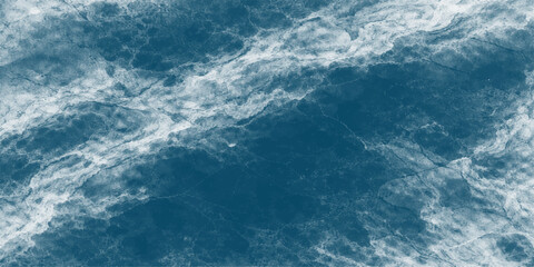 A bright summer sun shines through fluffy white clouds in a clear blue sky, reflecting light onto a beautiful abstract blue water surface with gentle waves for a calm nature background