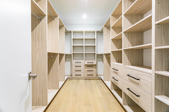Modern Walk In Closet With Custom Wood Built In Shelving and Drawers in Luxury Residential Interior