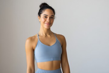 Fototapeta premium Young hispanic female in sportswear smiling confidently indoors