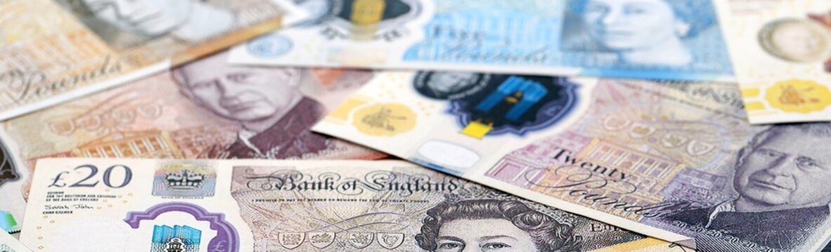 British pound money bills pile on table. United Kingdom banknotes of GBP currency close up.