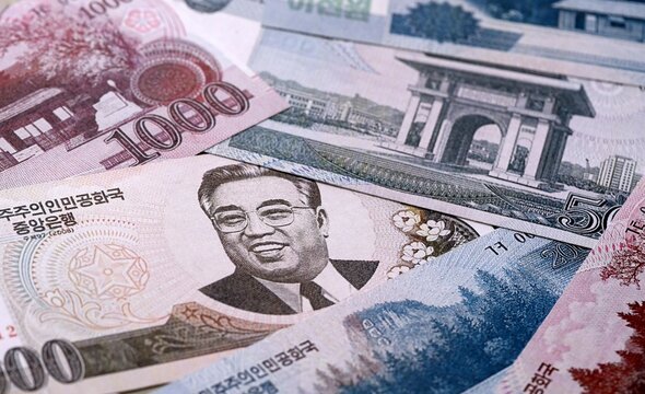 North Korean won money bills pile on table. North Korea banknotes of KPW currency close up.