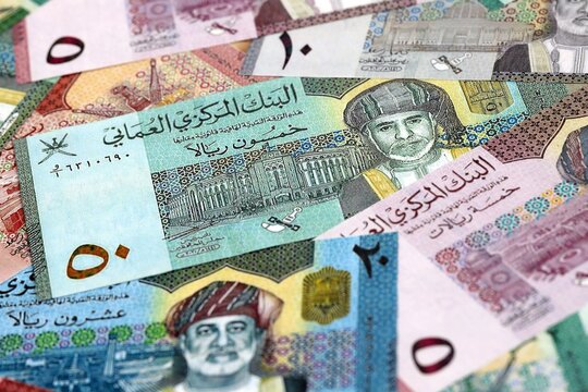 Omani rial money bills pile on table. Oman banknotes of OMR currency close up.