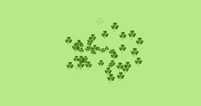 Digital animation of multiple clover leaves forming against green background