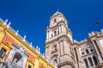 Fototapeta premium Ornate facade of Bishop Palace next to the Malaga Cathedral tower under blue sky