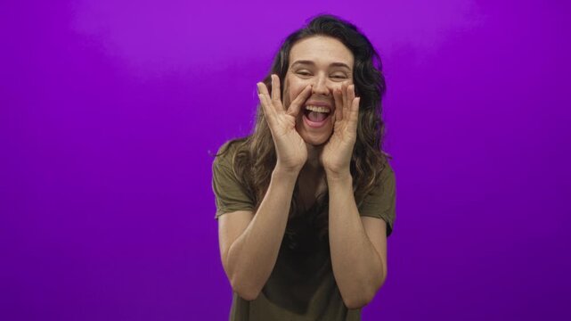 Young hispanic woman shouting and cupping mouth with hands in studio setting; announcement attention excitement.