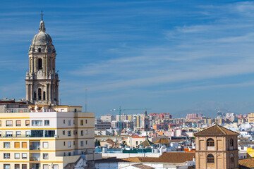 Obraz premium Malaga, Spain – Malaga city center skyline with cathedral tower and modern buildings viewed from the Mediterranean port waterfront with white pergola and blue sea water.