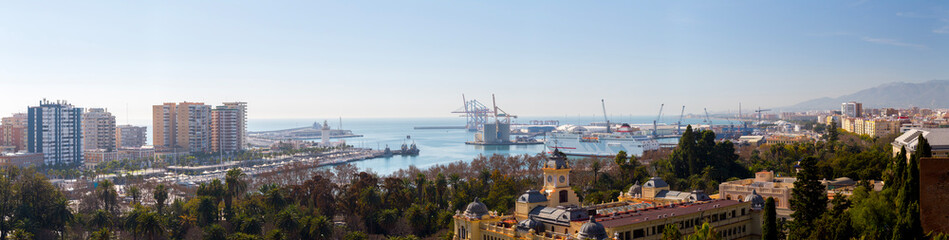 Fototapeta premium Malaga, Spain – Panoramic view of the Mediterranean port and city skyline featuring Malaga City Hall and maritime harbor in La Malagueta district from a high vantage point.