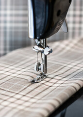 Close up of a sewing machine stitching on a piece of fabric