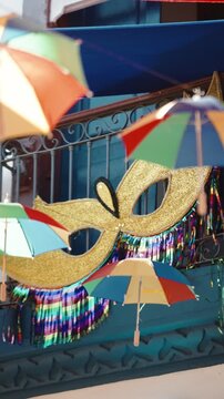 Decora&ccedil;&atilde;o e Borogod&oacute; Brasileiro em Tiradentes.
Close em m&aacute;scara dourada e sombrinhas de frevo balan&ccedil;ando ao vento. Detalhe da ornamenta&ccedil;&atilde;o a&eacute;rea do Carnaval mineiro.
