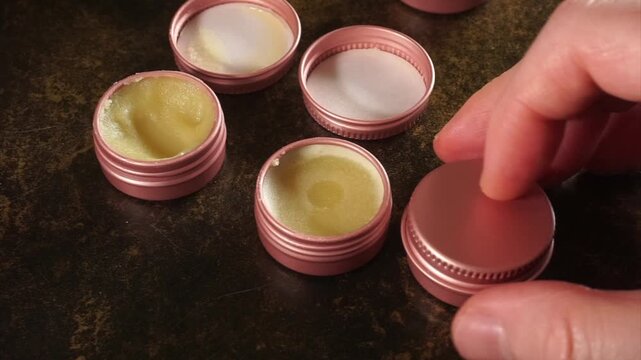 Hand packing homemade organic lip balm