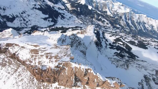 High Angle Aerial View of Sharp Snowy Mountain Ridge nd Deep Valley