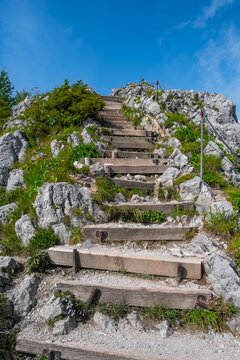 Wooden stairs leading up a rocky mountain to the summit in bright summer sun