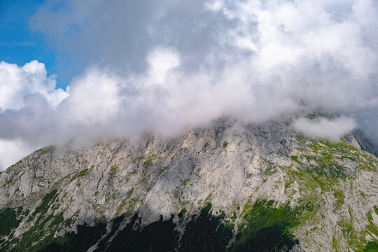 Thick white mist enveloping the summit of a stony mountain