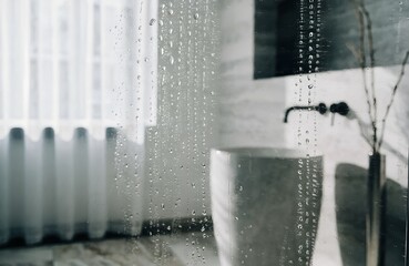 Steamy shower glass with water drops in a tranquil modern bathroom.