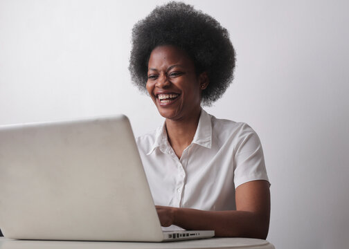 portrait of a laughing woman while uses a computer