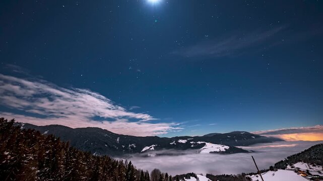 Timelapse of a milky way stars and starry night over the Italian mountains. Night landscape in the mountains with rocky mountain ranges and night sky with constellation stars and clouds.