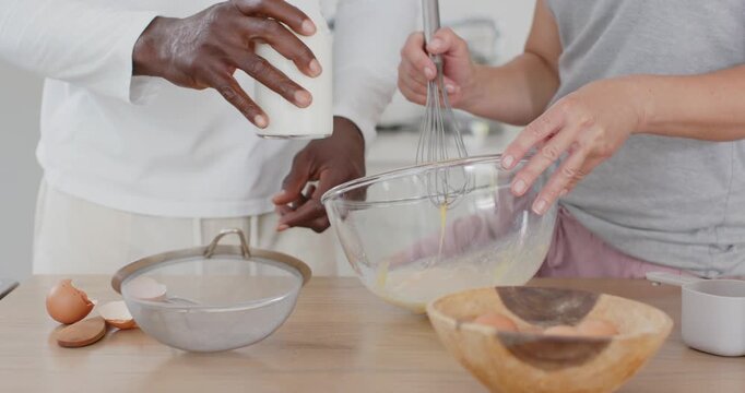 After cracking eggs, couple pouring and whisking batter at kitchen countertop with whisk and sieve