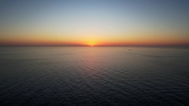 Aerial drone view of the Highest point of Malta at Dingli Cliffs, beautiful lush green grass and rock formations with a steep drop to the sea at sunset, golden hour. Sun giving the golden glow