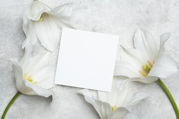 Square wedding invitation or save the date card mockup with white tulips flowers on trendy grey background, copy space