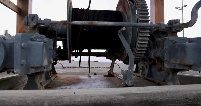 A large, rusted, old-fashioned whalers winch is sitting on the ground in Sao Vicente Ferreira