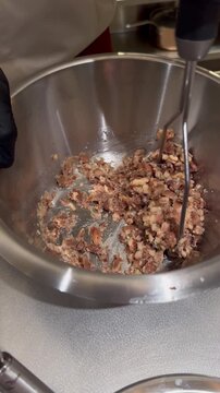 Professional preparation of traditional fava beans (Foul Mudammas), Arabic cuisine chef mixing breakfast dish.