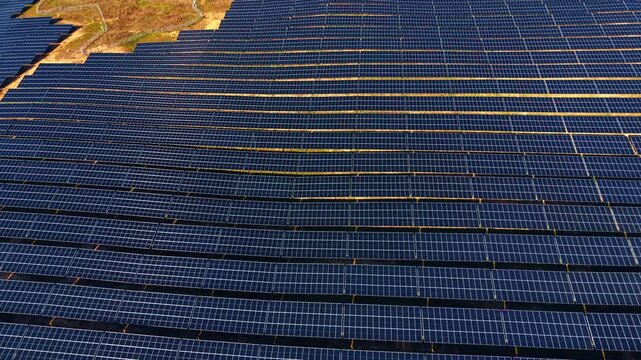 Aerial pattern of blue solar panel array. Symmetrical and repetitive pattern of photovoltaic modules at a solar power plant taken from above.