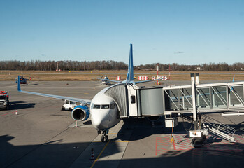 Airplane with terminal gangway to the airport building. Maintenance of aircraft before the flight