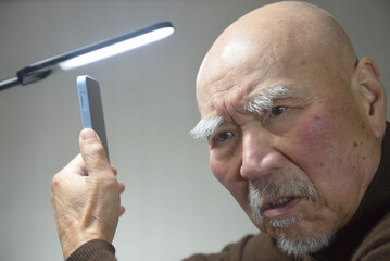 スマートフォンを操作する老人