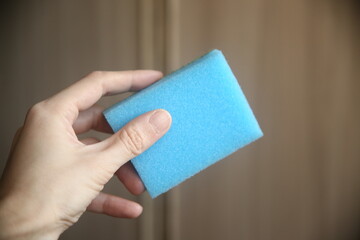 hand holding blue sponge