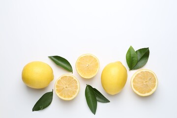 Fresh lemon fruits and green leaves on white background, flat lay. Space for text