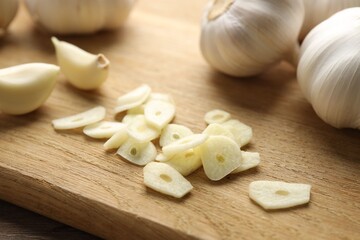 Fresh garlic bulbs and cloves on wooden table, closeup