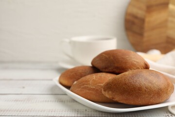Fototapeta premium Yummy baked patties served with tea on white wooden table, closeup. Space for text