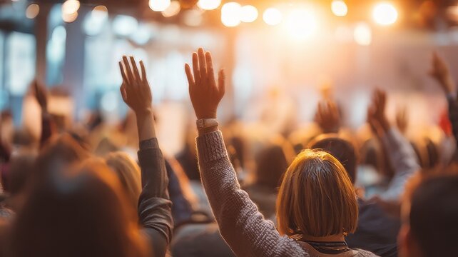 Professional conference audience raising hands  to ask questions during business presentation,hands of people raised at a concert 