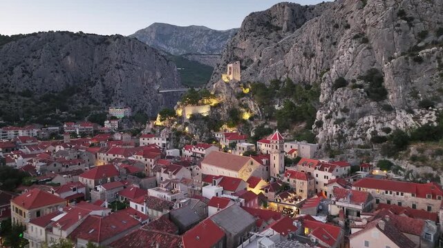 Aerial drone view of Church of Saint Michael and Mirabela Fortress in Omis during peaceful dusk light.