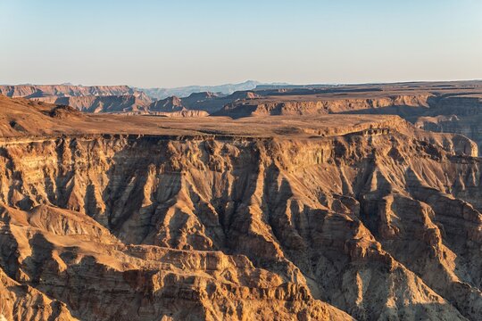 Namibia - Fish River Canyon - Scenic landscape showing deep winding geological formation and flat plateau horizon at sunset